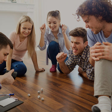 A group of people celebrating over rolling dice.