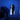 Two people in a blue-walled room with one looking into a small opening.