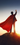 Photo of a man on a cliff wearing a superhero cape.
